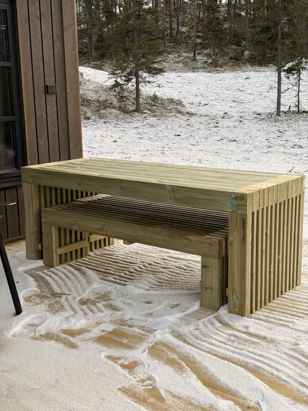 Massivt spilebord med benk mot skogkant