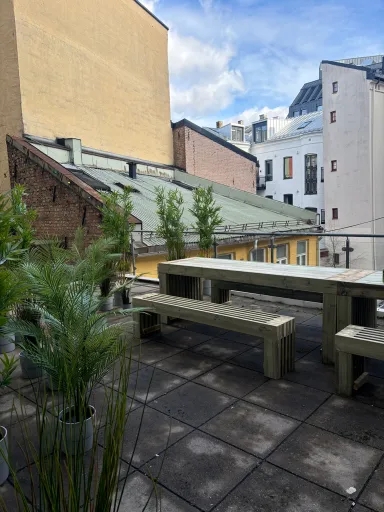 Langbord med benker på takterrasse i byen